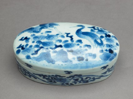 Box with cranes among flowersoblique