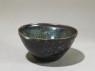 Black ware tea bowl with 'tortoiseshell' glazes (oblique)