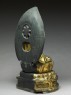 Figure of the Buddha with a mandorla, or halo, seated on a lotus pedestal (side)