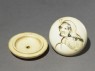 Manjū netsuke depicting Daruma playing the kamifuki game (oblique, open)